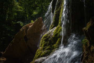 Fototapeta premium A beautiful waterfall deep in the forest, steep mountain adventure in the rainforest.