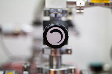 Pressure dial knob close up macro shot in a lab isolated against bright blurry background