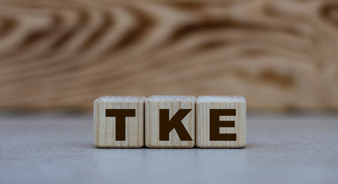 concept of the word TKE on cubes on a gray background with letters