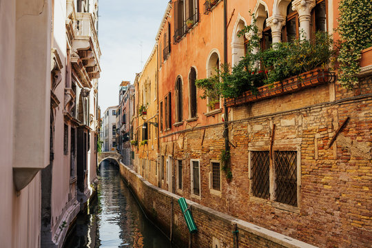 Image of bright colorful houses and bridge on Venetian lagoon. View of typical Venetian canal and colorful buildings in Venice, Italy with Grand Canal. Decoration on houses.