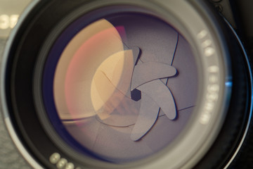 Vintage lens front element close up macro shot with light reflections and visible closed  aperture blades