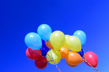 Two bouquets of balloons on a sky background. Colors - red, yellow, blue, orange. Concept of a...