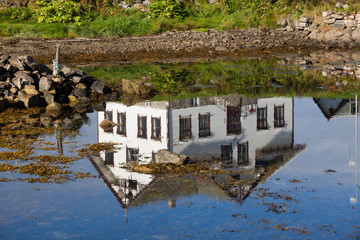 Fototapeta na wymiar Vesteralen Islands / Norway - August 28, 2017: Reflection in the sea from a house, Vesteralen, Norway
