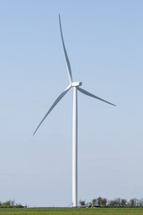 Electricity generating wind turbines with blue sky in background