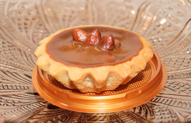 Shortbread basket with caramel and hazelnuts, taken in close-up.
