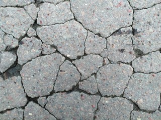 Cracks on the asphalt, road texture, wet asphalt background, mobile photo