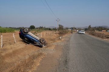 Fototapeta na wymiar Car accident with over turned car on road