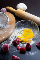 ingredients for baking with strawberries on a black table