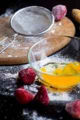 ingredients for baking with strawberries on a black table