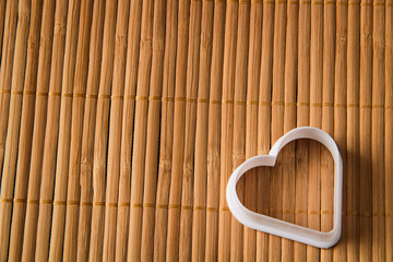 plastic molds for baking cookies in the form of hearts on a wooden background