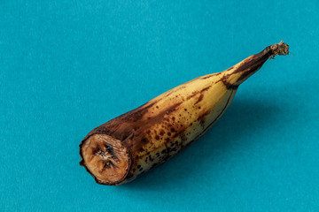 Banana, half banana, spoiled banana on a in blue background. Organic waste overripe fruit.