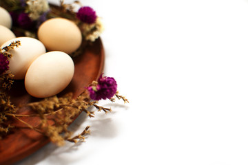 Brown clay plate with multi-colored dry flowers on a white background, isolate