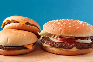 hamburger, burger and two cheeseburgers on a blue background