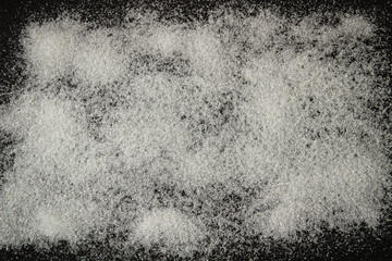 white sugar sprinkled on a black background