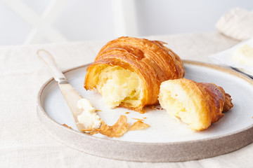 Coffee with croissant. Bright sunny morning, leisurely breakfast with fresh pastries, side view