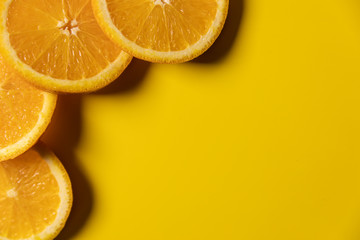 orange fruit slices on yellow background with copy space. top view