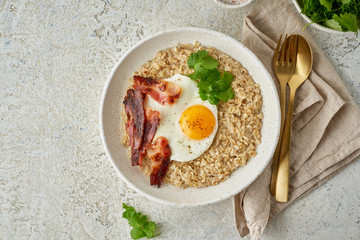 Oatmeal, fried egg, fried bacon. Balanced food. Intuitive conscious food, top view, copy space