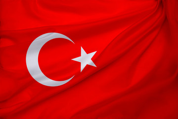 photo of beautiful colored national flag of modern state of Turkey on textured fabric, concept of tourism, emigration, economy and politics, closeup