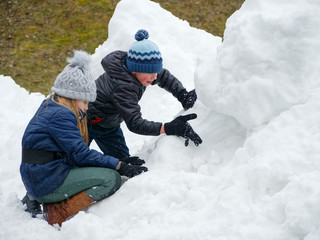Fototapeta na wymiar winter fun. cheerful child in a hat plays snowballs