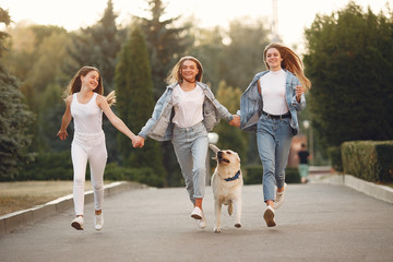 Obraz premium Beautiful girls walking. Women in a spring city. Ladies with cute dog.