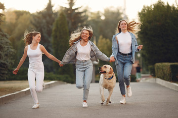 Beautiful girls walking. Women in a spring city. Ladies with cute dog.