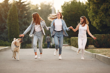 Obraz premium Beautiful girls walking. Women in a spring city. Ladies with cute dog.