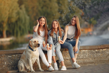 Beautiful girls eating ice cream. Women in a spring city. Ladies with cute dog.