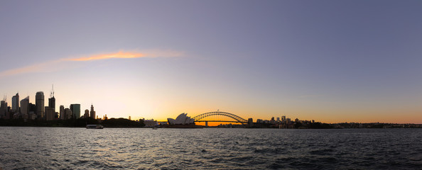 Fototapeta na wymiar Panoramic View of Sydney Harbour on a warm summer afternoon blue and orange skies illuminating Sydney Harbour Bridge