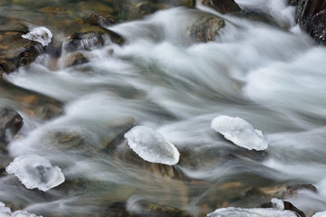 Winter landscape of Clear Creek with ice formations captured with motion blur, Rocky Mountains, Colorado, USA