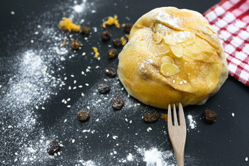 Freshly backed currant sourdough bread, top view. Artisan bread with seeds on black table. Rustic sourdough bread.