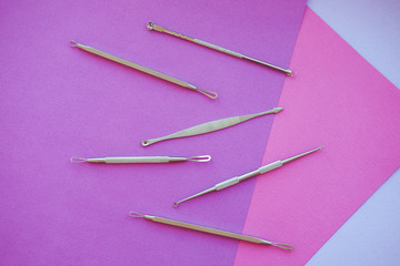 Tools for removing acne. Tools of the cosmetologist for problem skin on pink paper background.