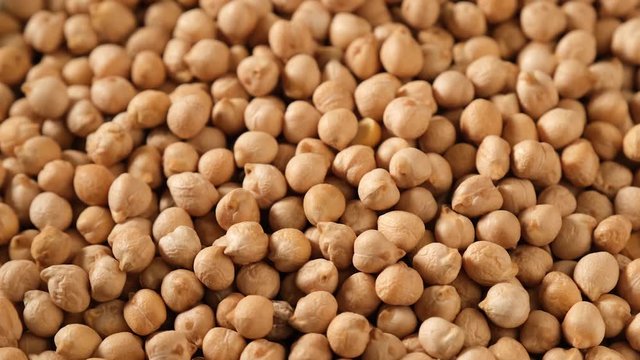 Food video of dried uncooked chickpeas, rotating. Raw cereal. Macro.
