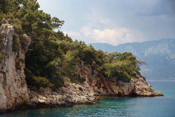Fototapeta na wymiar Beautiful islands of the Aegean Sea with pine forest, rocks, deep blue water and mountains in the background. Marmaris, Turkey