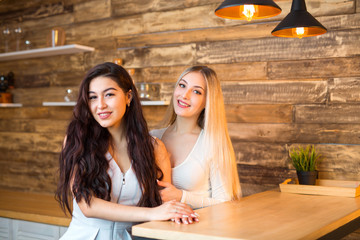 two beautiful young women are sitting at the table