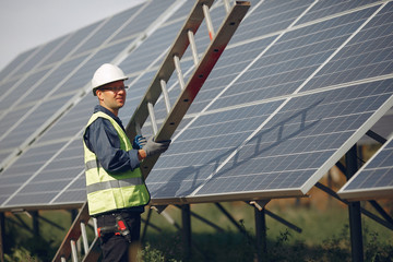 Engineer in a white helmet. Man near solar panel. Worker with a ladder © hetmanstock2