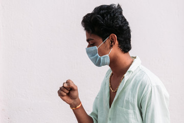Indian Man coughing while wearing the mask to prevent himself from corona virus pandemic