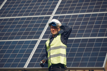 Engineer in a white helmet. Man near solar panel.