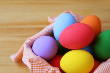Closeup Colorful Easter Eggs in a Basket on Wooden Table