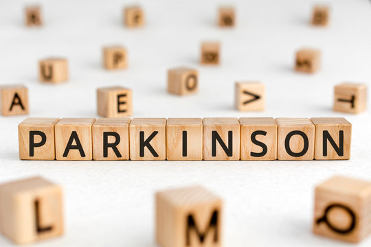 Parkinson - word from wooden blocks with letters, parkinson disease of the nervous system concept, random letters around white background