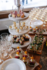 Glasses with seafood snacks and meat on banquet table