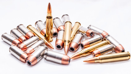 Four different caliber bullets, 223 rifle bullets, 9mm, 40 caliber and 45 auto on a white background