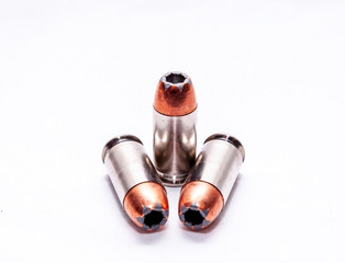Three .45 auto hollow point bullets on a white background