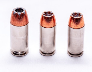 Three different caliber handgun hollow point bullets, 9mm, 40 caliber and 45 auto on a white background