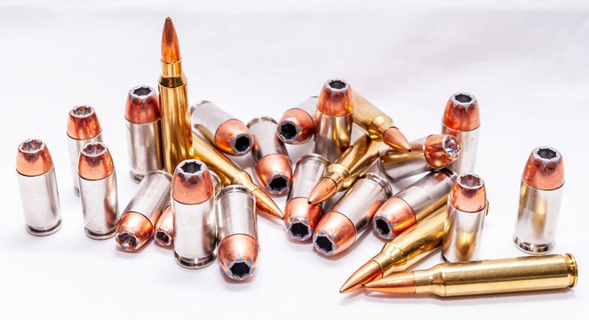 Four different caliber bullets, 223 rifle bullets, 9mm, 40 caliber and 45 auto on a white background