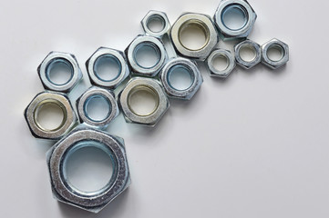 New chrome screw-nut of different sizes on a white background. Concept.