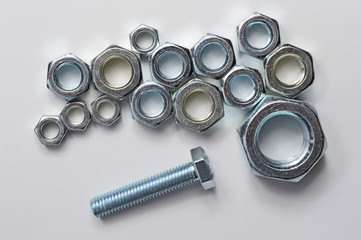 New chrome screw-nut of different sizes on a white background. Concept.
