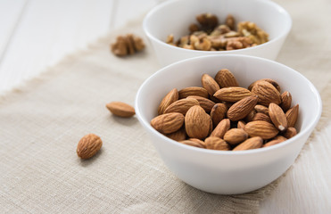 diet food concept, almonds in a white plate on a wooden table