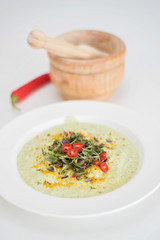 Anti-inflammatory vegan food. Cauliflower and broccoli soup with fresh red chili slices, turmeric and thyme