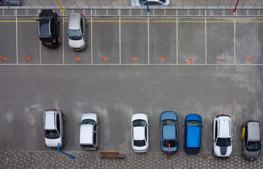 Car parking aerial top view. Occupied and vacant lots with vehicles. Park marked area of modern urban structure. City landscape pattern
