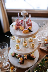 Glasses with seafood snacks and meat on banquet table